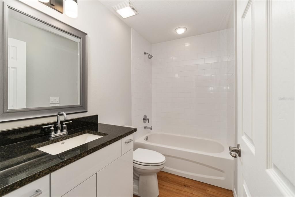 Guestbath with Granite Countertop and Tiled Shower