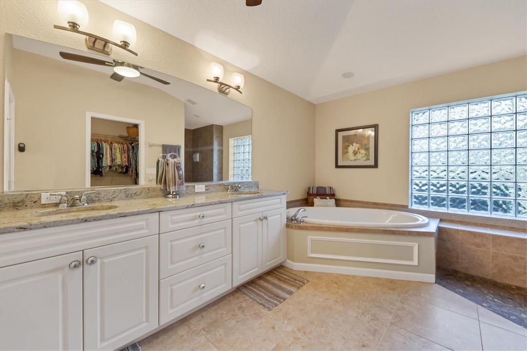 en suite has updated vanity, dual sinks and gorgeous granite counter - soak tub, walk in closet and walk in Roman Shower