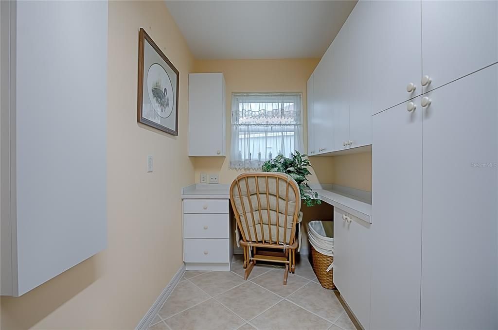 Laundry room has a desk area and plenty of extra cabinets