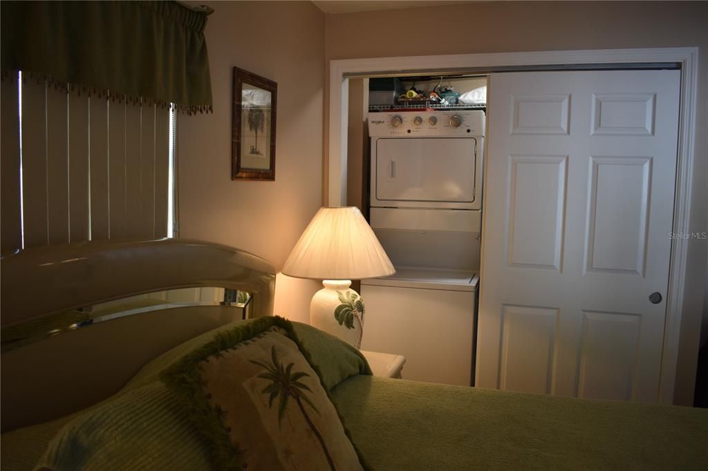 Guest bedroom and closet with washer and dryer