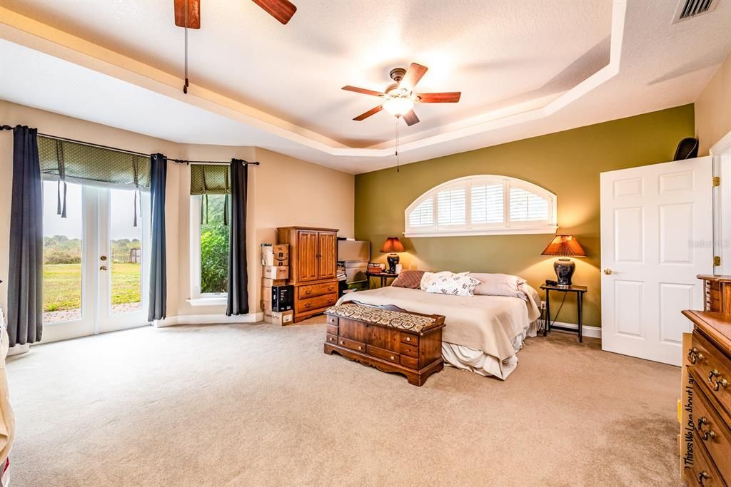 A private OWNER’S SUITE is also on the main floor and delivers a lovely TRAY CEILING, dual ceiling fans, FRENCH DOOR ACCESS to the PATIO, a WALK-IN CLOSET with CUSTOM BUILT-IN’s and a SPA LIKE EN-SUITE BATH!