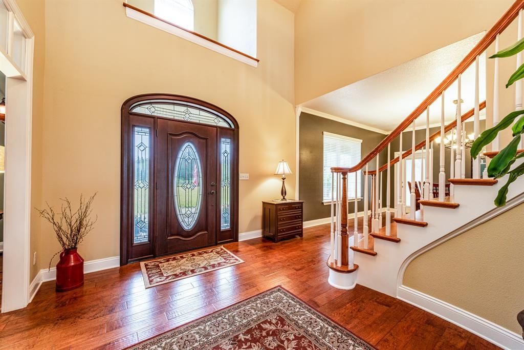 Entering this stunning home you will note the almost 20’ ceilings in the foyer and family room, as well as the hand scraped HARDWOOD FLOORS, crown molding and custom features throughout!