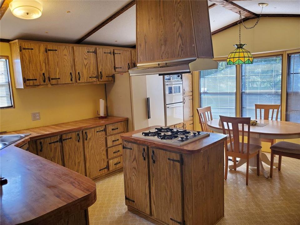 Large functional kitchen with lots of cabinets, gas cooking, built-in oven and double door refrigerator.