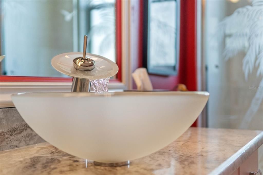 Water fall faucet on granite guest vanity.