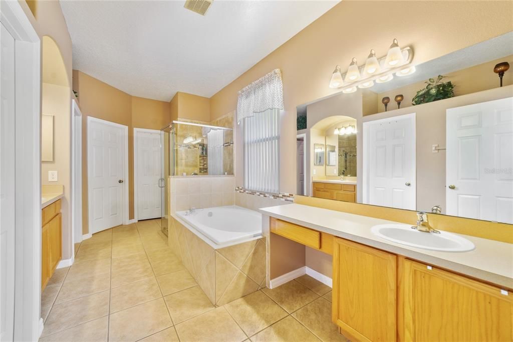 Beautiful EN-SUITE BATH offers his and her vanities, a SOAKING TUB and large TILED SHOWER with SEAMLESS GLASS DOORS!