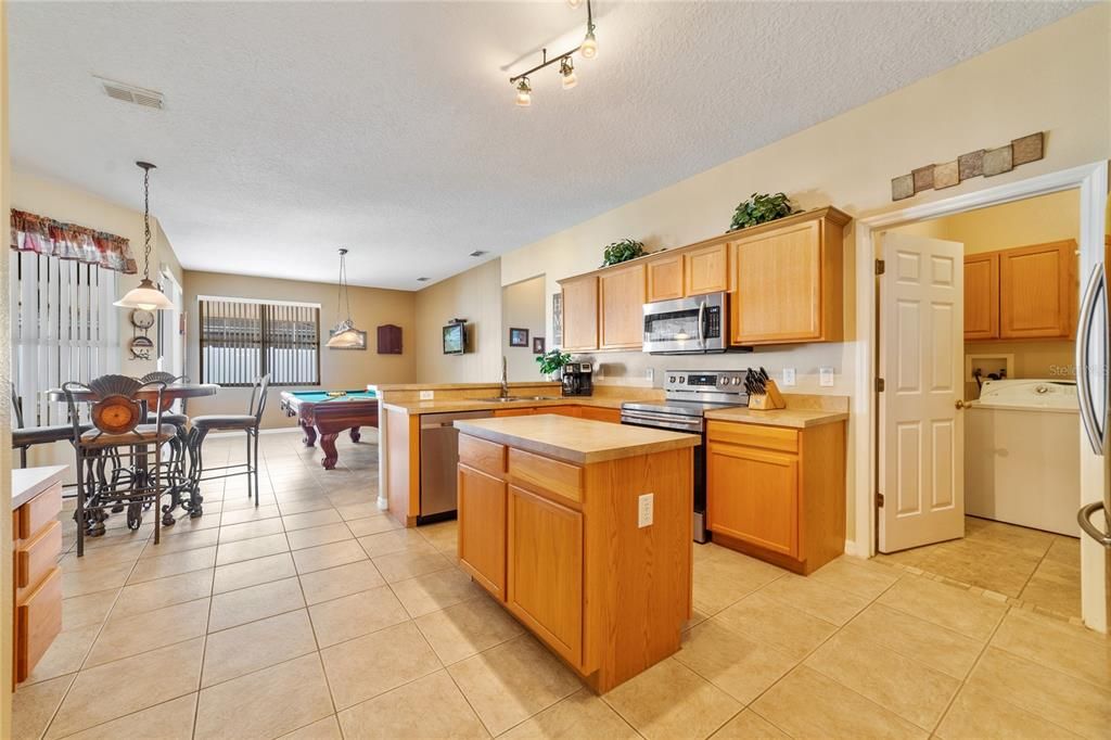 From there this bright flowing floor plan opens up into the FAMILY ROOM and EAT-IN KITCHEN with sliding glass door access to the expansive screened lanai!