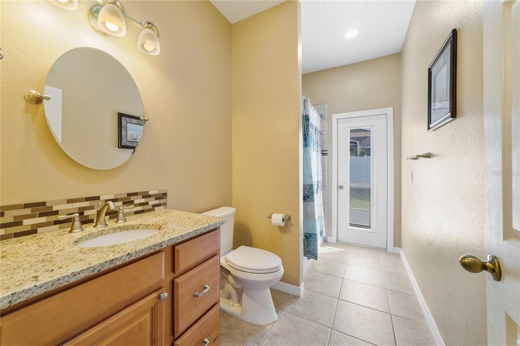 Updated SECOND FULL BATH has granite counters, a tiled shower and patio access!