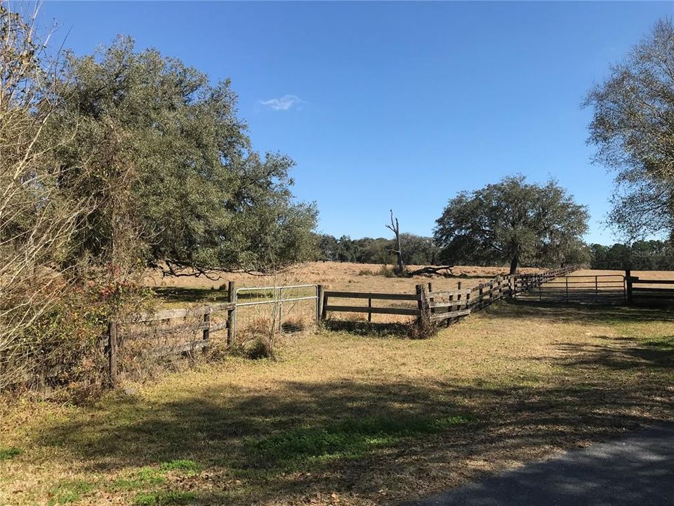 Southwest corner of property with wood fence and gate.