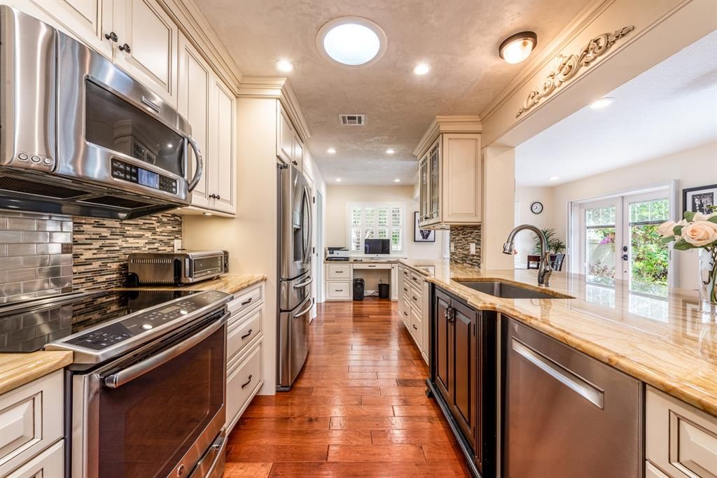 The heart of this home is the stunning custom kitchen boasting UPGRADES throughout in the STAINLESS STEEL APPLIANCES, cabinetry, countertops and backsplashes.