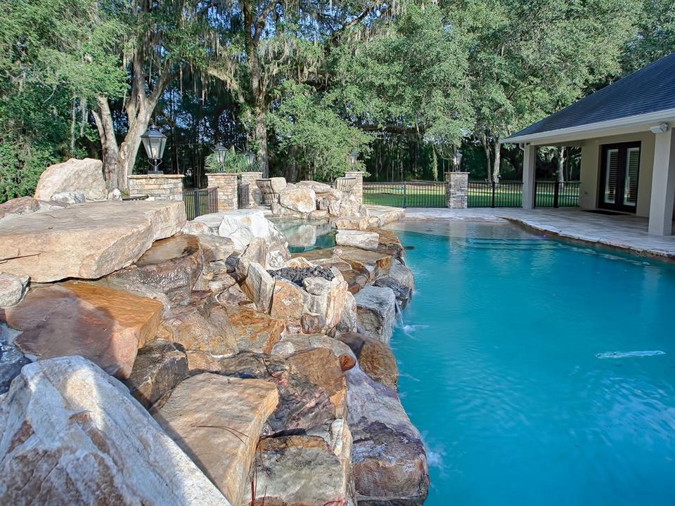 THIS POOL HAS A ROCK WATERFALL FEATURE! ALSO NOTE THE SPA IN THE DISTANCE!