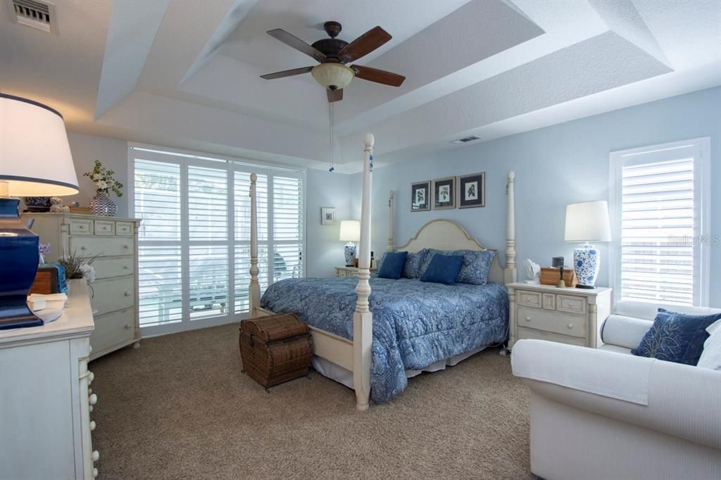 Master Bedroom with coffered ceilings, plantation shutters and private patio with inground jacuzzi.