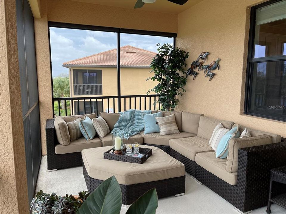 The lanai is beautifully decorated for leisure and entertaining.  The seating area looks over the water and the 12th green.