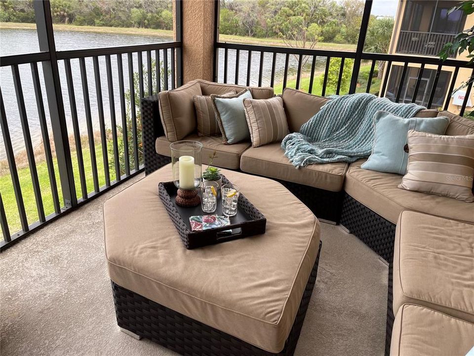 The lanai is beautifully decorated for leisure and entertaining.  The seating area looks over the water and the 12th green.