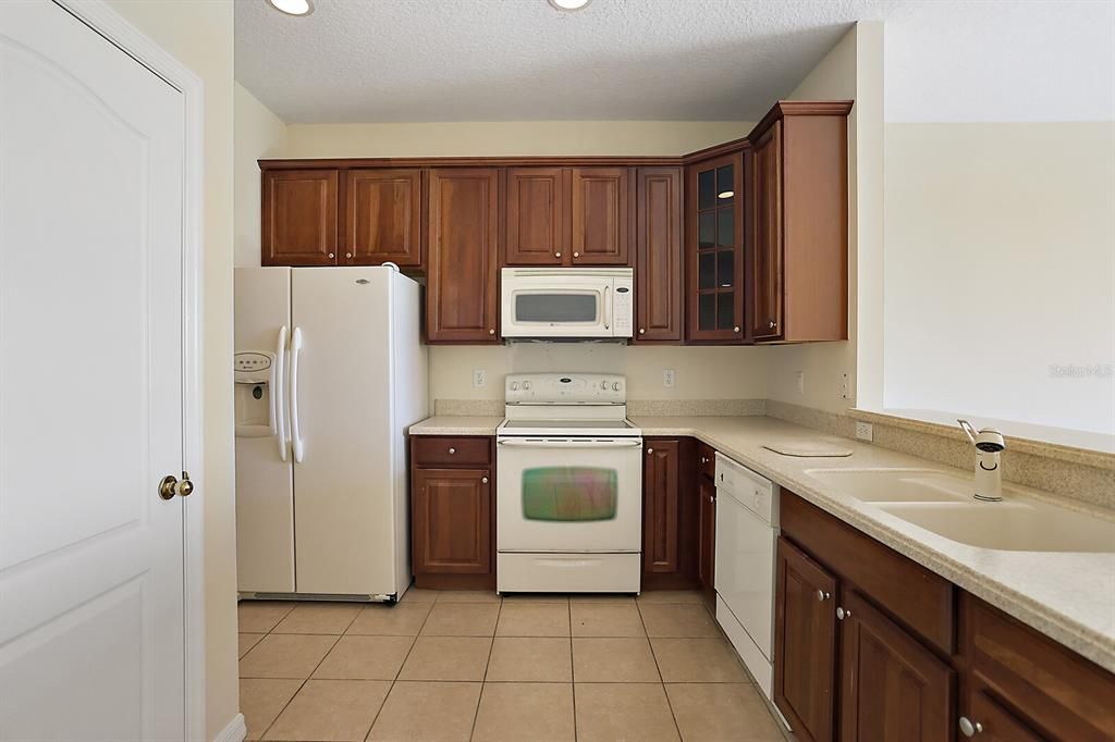 Cream colored appliances and cabinets are a rich shade of walnut