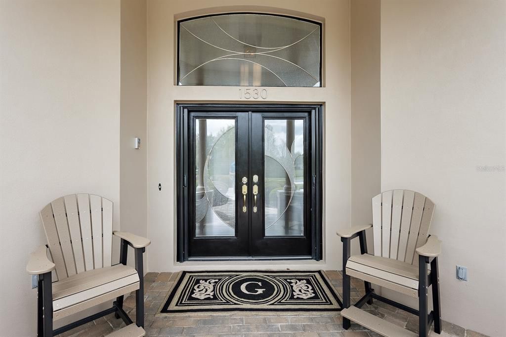 Covered front entrance with elegant leaded glass double doors