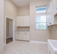 Spacious Laundry Room with Custom Cabinets, Utility Sink and Corian Countertops