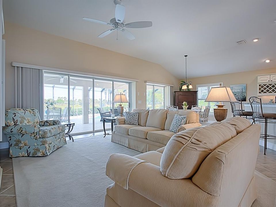 LVIING ROOM WITH A FULL WALL OF SLIDING GLASS DOORS TAHT OPEN OUT TO THE LANAI AND POOL!