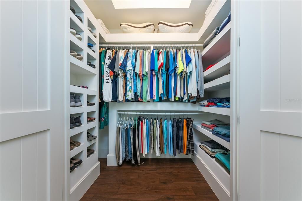 Two custom designed walk-in closets in the primary suite offer wood shelving, built-in drawers, shoe cubbies, floor to ceiling mirrors, occupancy sensors, and additional upper storage shelves.