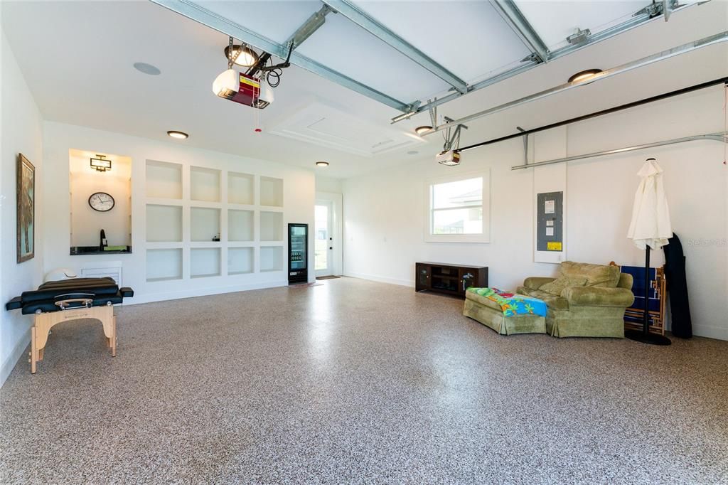 Yes, this is really the garage, with upgraded Wood-Look garage doors, an epoxy floor, a glass-front beverage cooler, a utility sink with a granite top and upgraded faucet/fixtures, specialty lighting, and aesthetically pleasing seamless trim around the garage doors (no bolts visible).