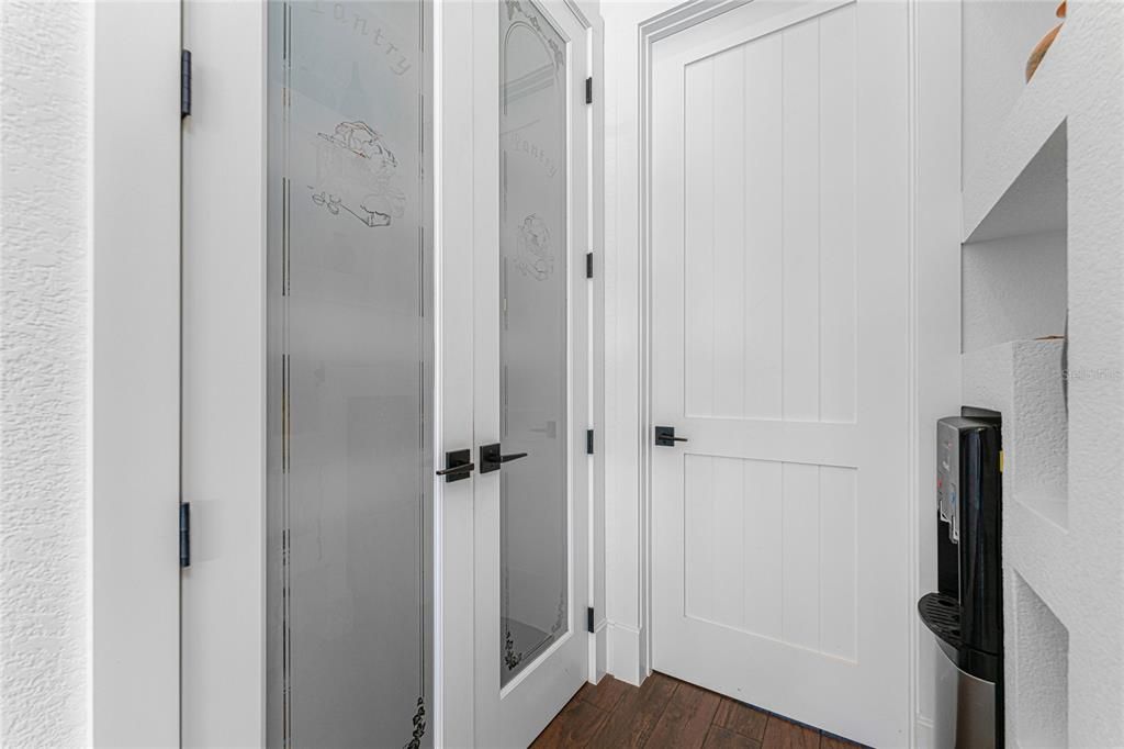 A custom pantry with wood shelves and double glass doors was incorporated to accommodate your storage needs.