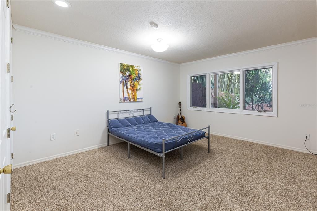 Guest bedroom on lower level with views to pool and lake