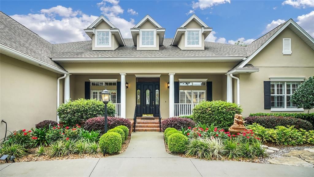 Such an inviting entry with beautiful roses, flagstone walkways to either side of the home and a front porch that beckons.