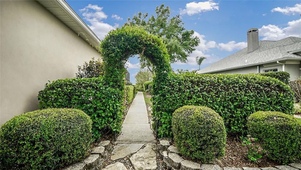 The Carolina Jasmine archway is inviting you to stroll along the side of this home and enjoy the outdoors.
