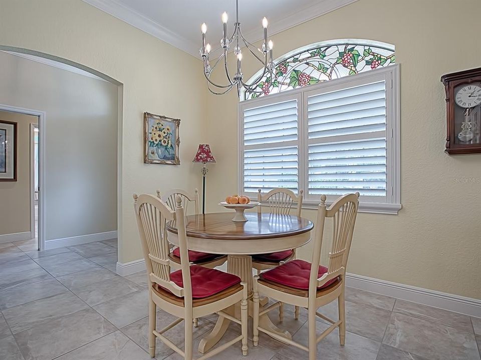 TO THE LEFT OF THE FOYER IS THE CASUAL DINING AREA RIGHT OFF THE GORGEOUS REMODELED KITCHEN! LOVELY WINDOW TREATMENTS WITH PLANTATION SHUTTERS AND CUSTOM STAINED GLASS TRANSOM!