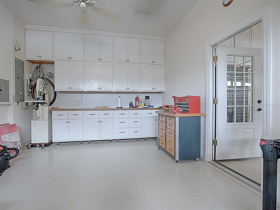 A QUICK PEEK INTO THE 3 GAR GARAGE WITH A WORKSHOP AND CUSTOM CABINETS FOR MORE STORAGE SPACE!  THE OTHER SIDE OF THE GARAGE HAS ANOTHER FULL WALL OF CABINETS!  YOU'LL ALSO FIND PULL DOWN ATTIC STAIRS AND A WATER SOFTENER!