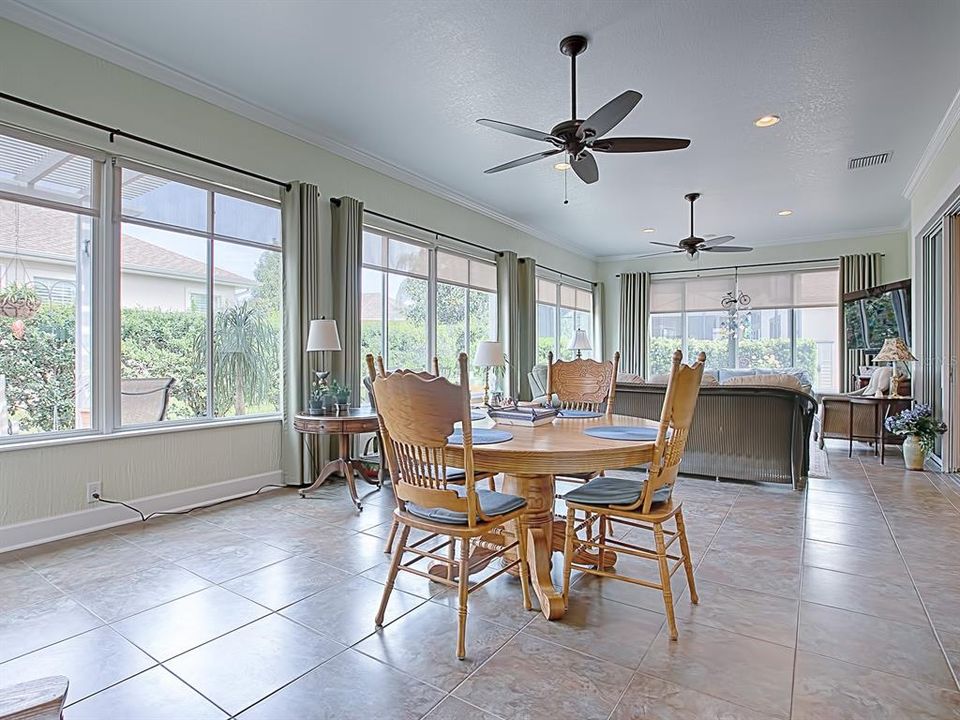 EXPANSIVE GLASS ENCLOSED FLORIDA ROOM WITH CERAMIC TILE FLOORING, SUN SHADES AND WINDOW TREATMENTS!