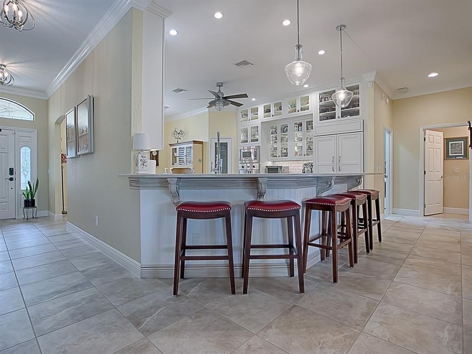 PENDANT LIGHTING OVER THE BREAKFAST BAR WITH CORBELS AND BEADBOARD FINISH! THE OPEN DOOR TO THE RIGHT IS AN ADDED 1/2 BATH!  TO THE LEFT IS THE EXPANDED LAUNDRY ROOM!