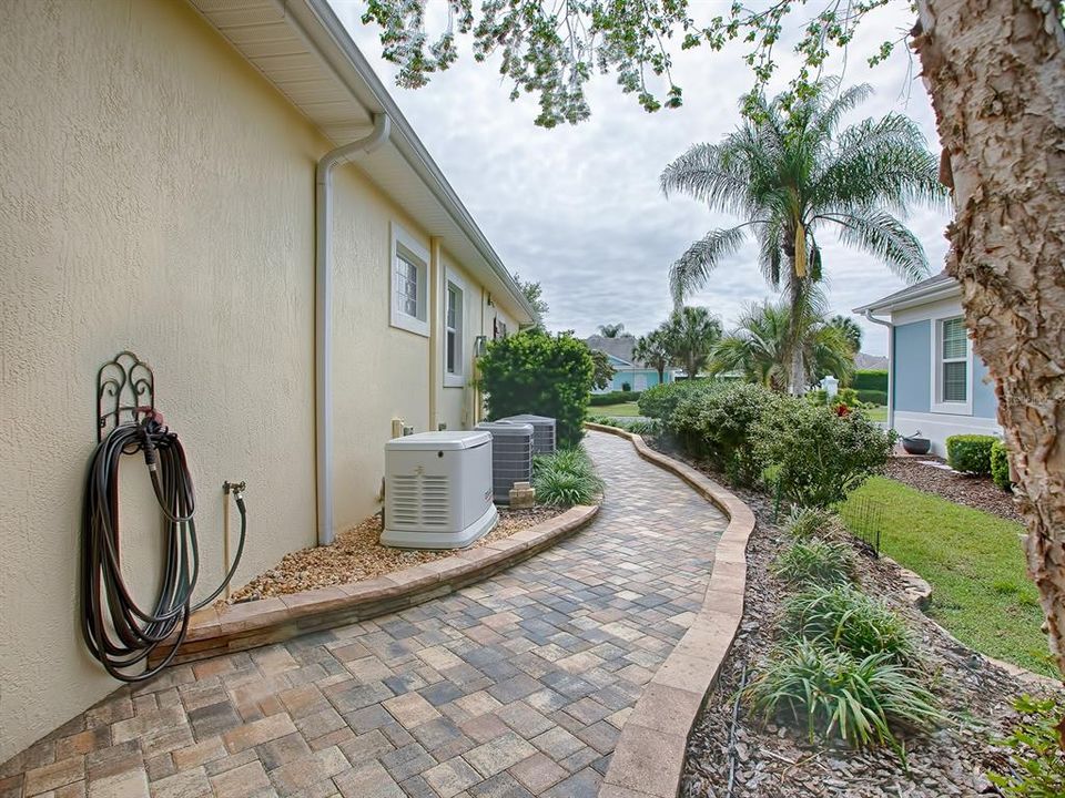 PAVERED WALKWAY ON THE RIGHT SIDE OF THE HOUSE TO THE FRONT DRIVEWAY!  NOTICE WHOLE HOUSE GENERATOR TOO!