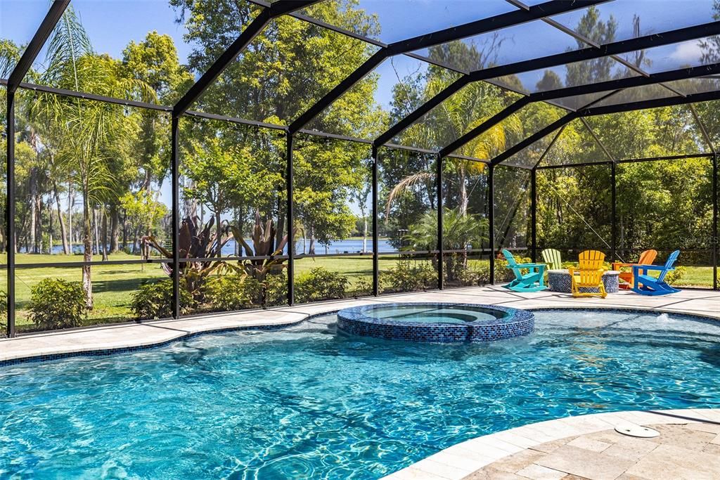 The lakefront oasis begins with a large and luxurious pool with travertine deck, spa and fire-pit.