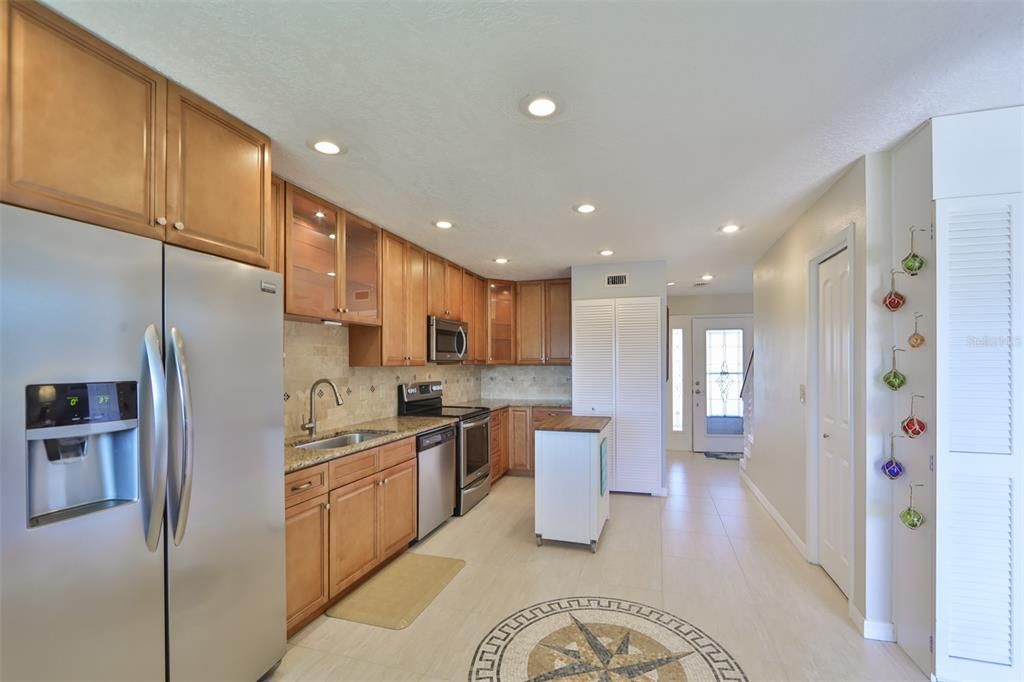 Kitchen is well lit with multiple recessed light fixtures.  The open area is easy for multiple cooks or entertaining.