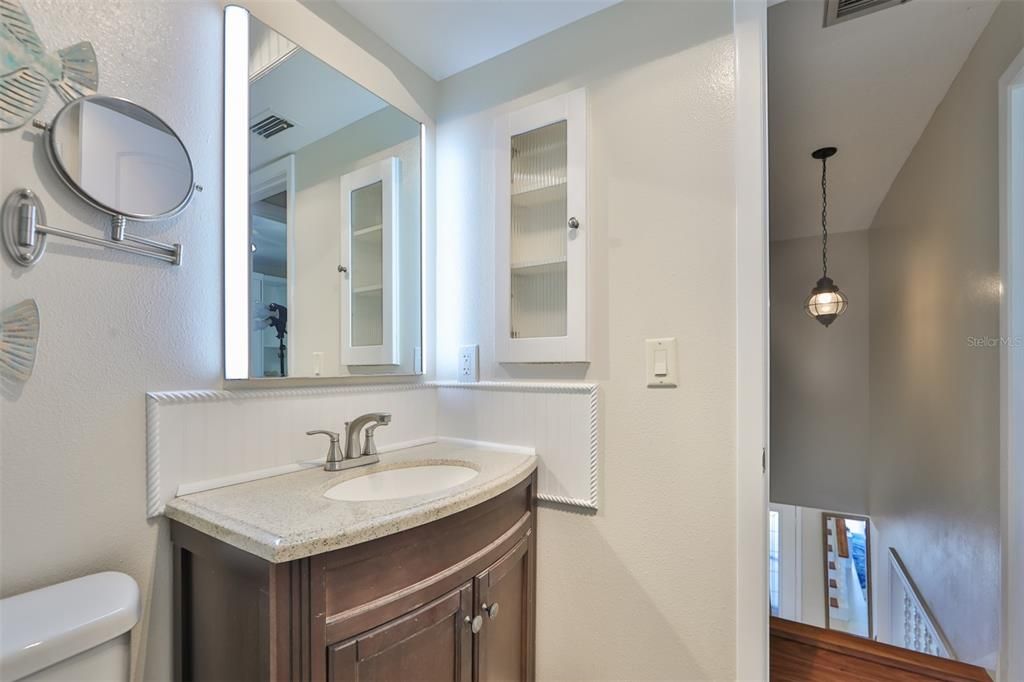 Upstairs bathroom has a wonderful touch sensitive lighted mirror and granite counter top vanity with custom rope features to continue the nautical/coastal theme.