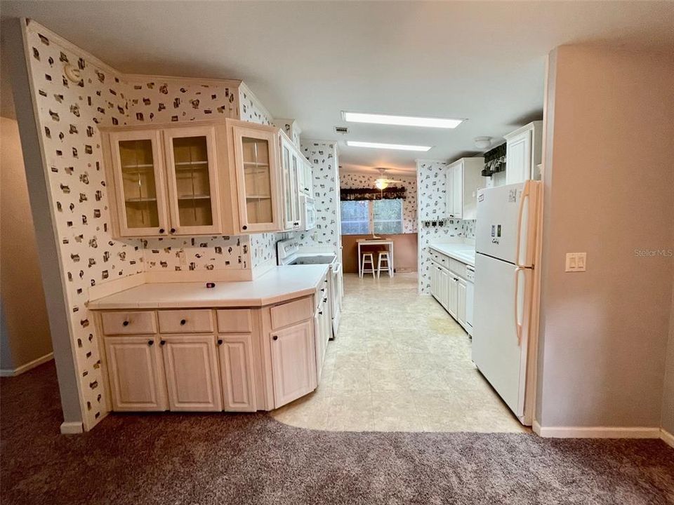 Kitchen, ample amount of cabinets, pantry closet just beyond the stove. Breakfast nook and laundry at the back of the kitchen, exit thru sliding doors to the back of the home. Kitchen has crown molding.