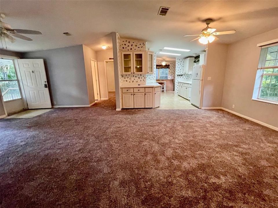 Another view of the great room... carpet is more gray, lighting isn't the true color, looking into the kitchen/breakfast nook, where you will find the indoor laundry as well. 2nd bedroom and hall bath is down the hall