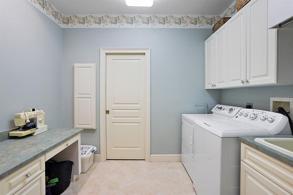Laundry room with work area and large pantry closet.