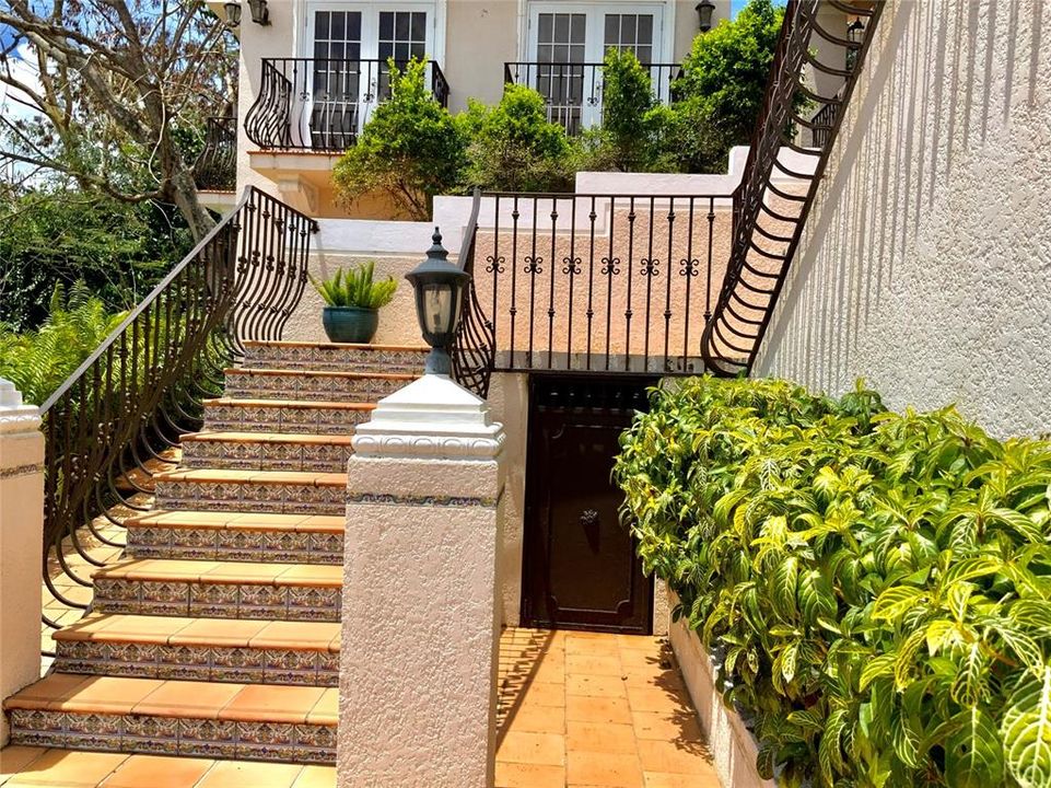 Elegant iron work and Spanish tiles with a beautiful iron door that leads into a storage area