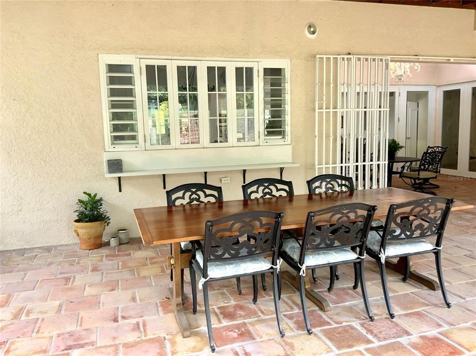 High wooden ceilings covered terrace with kitchen windows that open to terrace