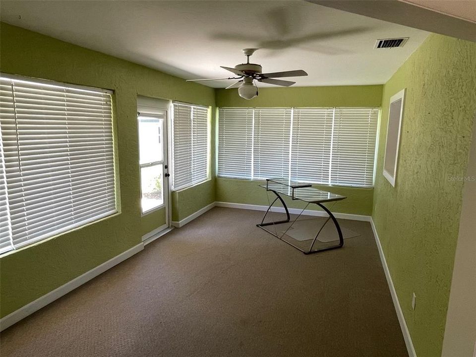 Florida room adjacent to kitchen. Door opens to walkway to rear yard and workshop and storage shed. Pass through from kitchen is on the right wall.