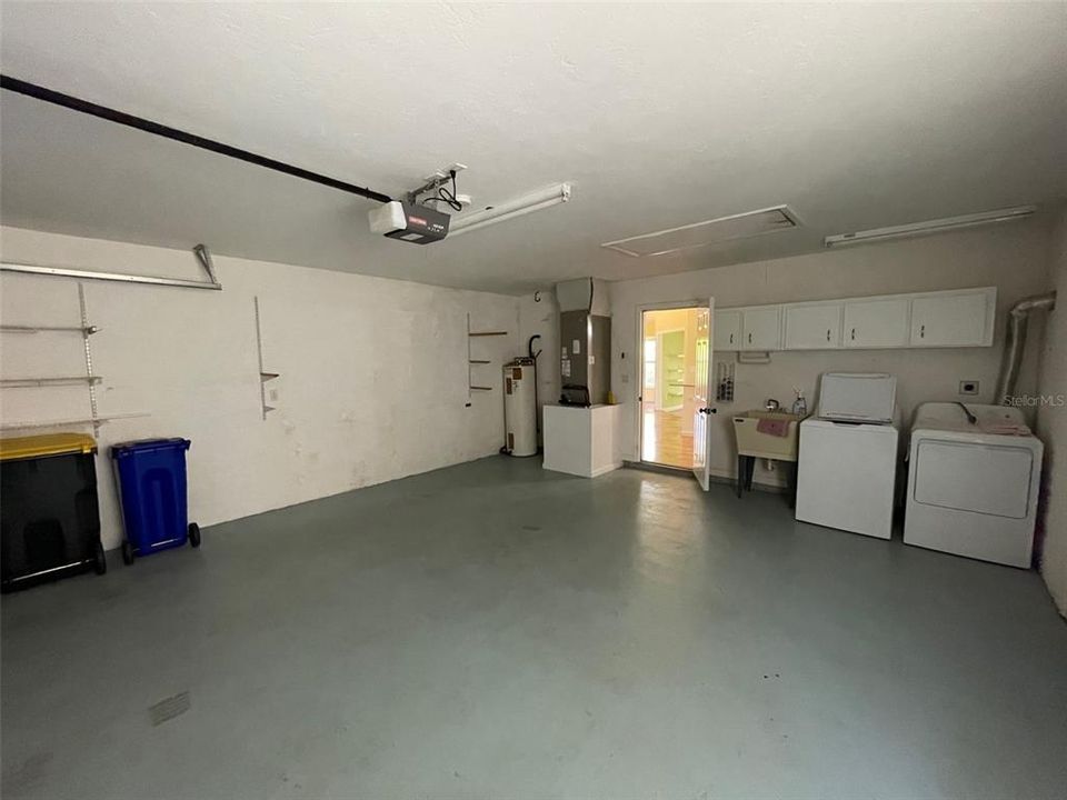 2 car garage with laundry hook-ups, sink, cabinets, looking toward kitchen.