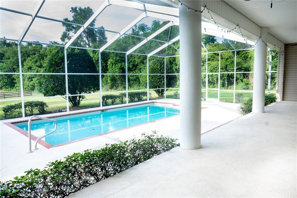 14.5'x30'screened pool with steps and swim-out. Outdoor kitchen cabinets (not shown) and large area to entertain with 2 fans on the top level. Two side doors to outside.
