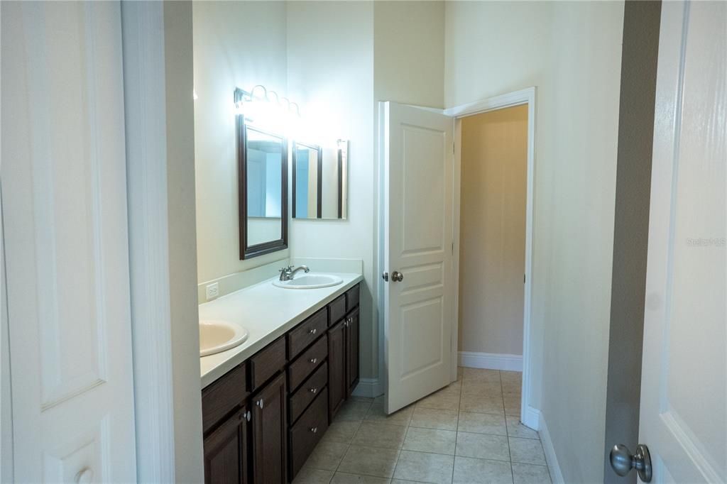 Master bathroom has double sinks, separate water closet room, linen closet, large supply closet, built-in wood open shelves, newer West Shore Shower with shower bench - 2020.
