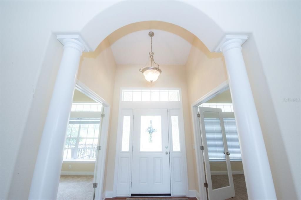 Impressive entry with pillars. Clear glass French doors to flexible rooms/office.