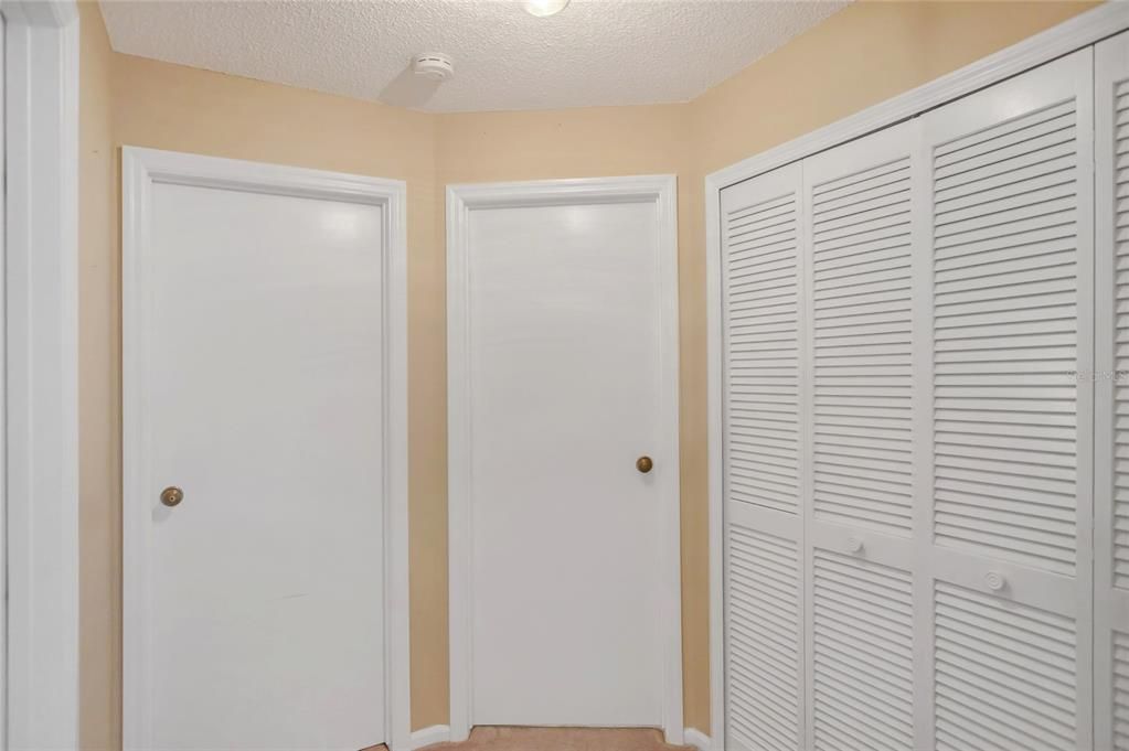 On the right is the laundry closet with shelving. The 2 doors lead to bedrooms #2 and #3. Guest bathroom is far left.