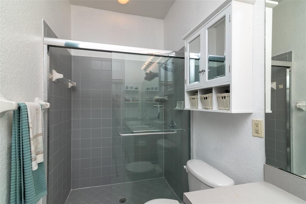 The master shower has a glass shower door and a ceramic tile surround.