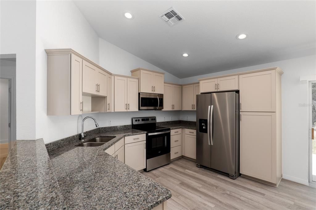 Stainless Steel appliances and a full size pantry to the right of the Fridge