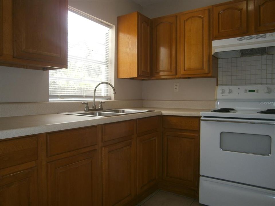 Efficient L-shaped kitchen. Wood cabinetry.