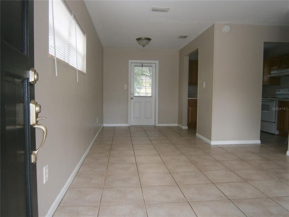 Enter into Living Room with Dining area conveniently adjacent to kitchen (Right left in photo).